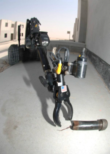 Talon robot picking up a potential explosive