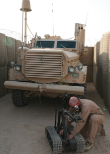 A soldier works on a TALON robot in Iraq